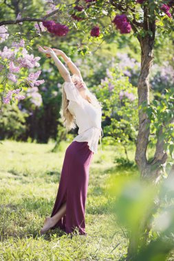 Bir bahar bahçe çiçek açan leylaklar ile güzel kadın