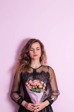 Güzel genç kadın ile narin pembe gül buketi