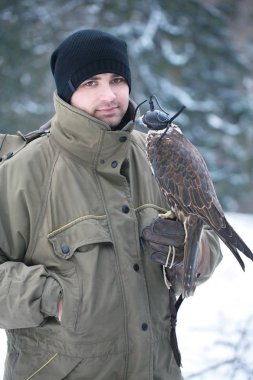 Yakışıklı delikanlı bir şahin kolunu tutan