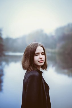 Nehrin üzerinde bir uçuruma uzun siyah bir ceket kadında