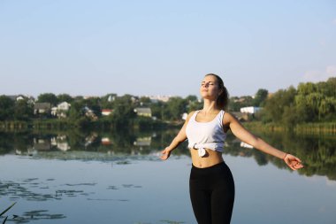 Genç kız neşe ve ilhamla elini uzatıyor. Güneşe bakıyor.