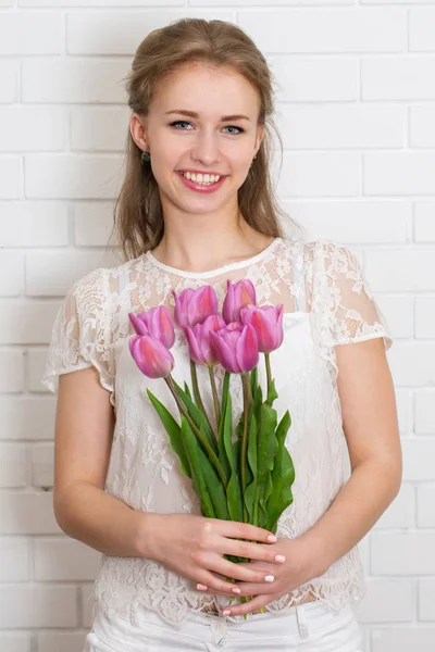 チューリップの大きな花束を持つ若い美しい女性 — ストック写真