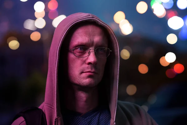 夜の街の灯の背景に眼鏡の若い男 — ストック写真