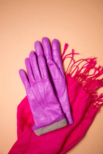 pink gloves on a pink scarf on a beige background