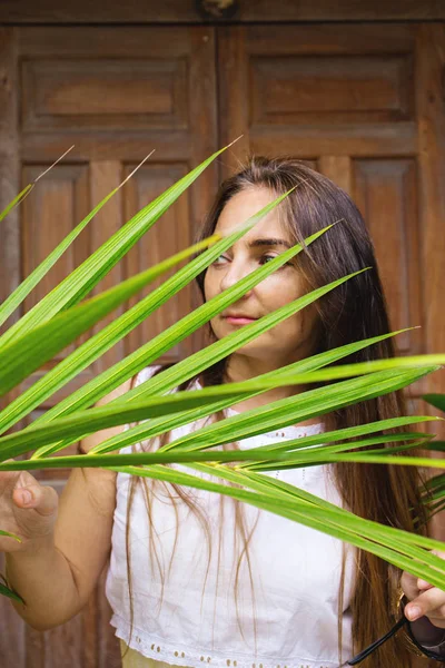 Bir Kadın Bir Palmiye Yaprağı Arkasından Bakıyor — Stok fotoğraf