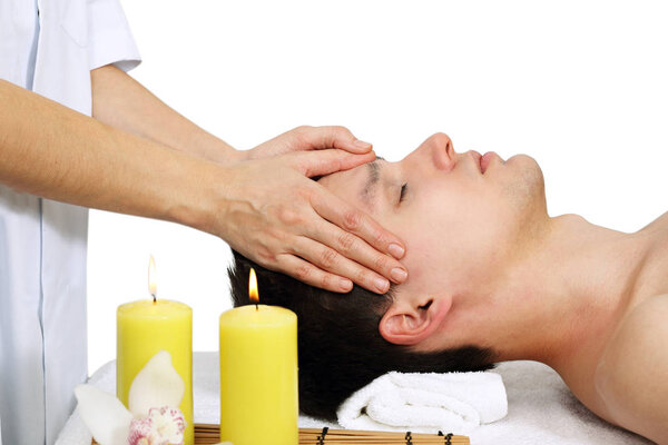 The young man gets a head massage. Isolated on white background