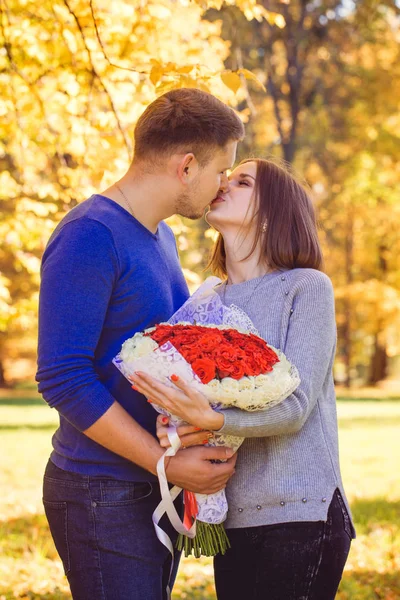 一个年轻的男人给他的女人一束玫瑰花 — 图库照片