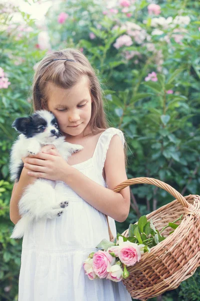 Κοριτσάκι Που Κρατάει Ένα Κουτάβι Στην Αγκαλιά Στον Κήπο — Φωτογραφία Αρχείου