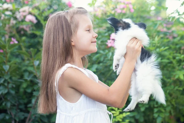 Küçük Kız Bahçede Kollarında Bir Köpek Yavrusu Holding — Stok fotoğraf