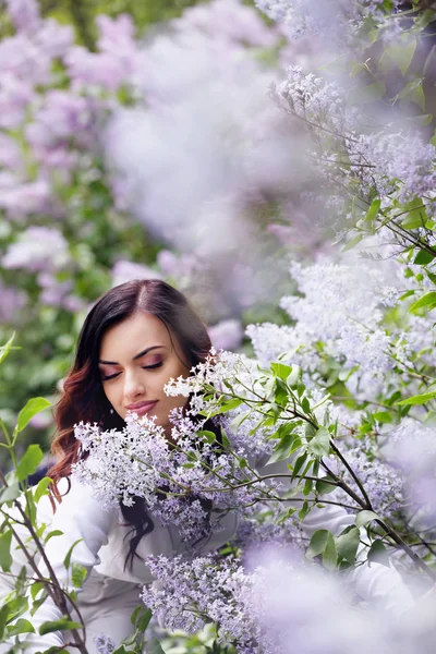 美丽的女人 在春天的花园与盛开的丁香花 — 图库照片