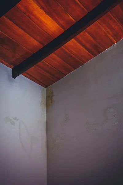 Red wooden ceiling and water drops on white walls
