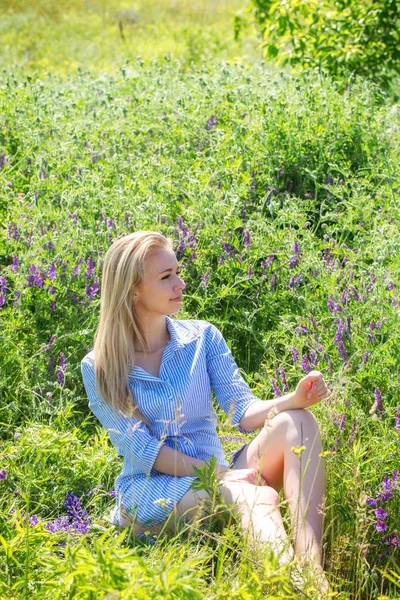 開花草原で休んで美しい金髪の若い女性 — ストック写真