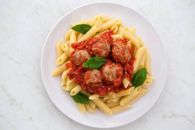 Beyaz bir arka plan üzerinde beyaz bir tabak makarna penne