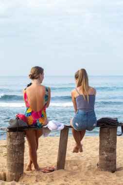 İki arkadaş dinlenme Okyanusu yakınlarındaki bankta