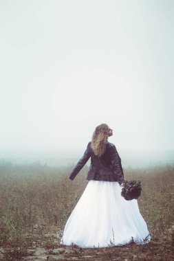 Sisli bir alanın arka plan üzerinde bir buket ile güzel gelin