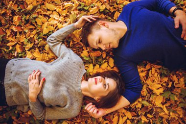 Genç erkek ve kadın üzerinde sonbahar yaprakları yalan
