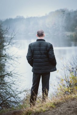 Nehir kıyısında bir sıcak siyah ceketli adamı emekli