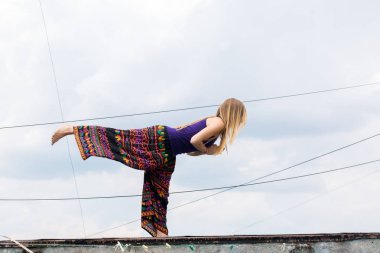 Binanın çatısında yoga yaparken kız