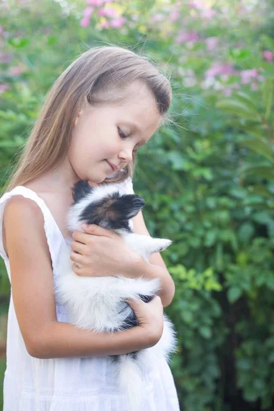 Küçük Kız Bahçede Kollarında Bir Köpek Yavrusu Holding — Stok fotoğraf