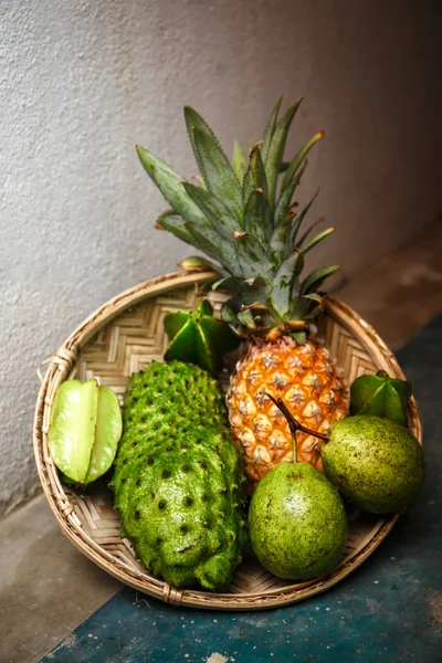 Tropical fruit in a wicker basket on a concrete floor