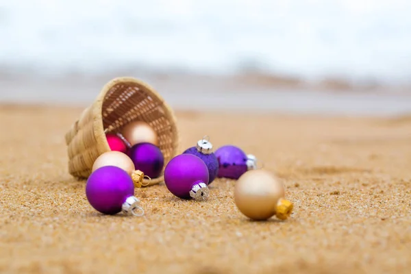 Christmas balls on a sandy beach by the ocean