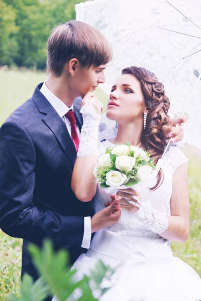 Braut Und Bräutigam Unter Einem Regenschirm Der Nähe Von Akazien — Stockfoto