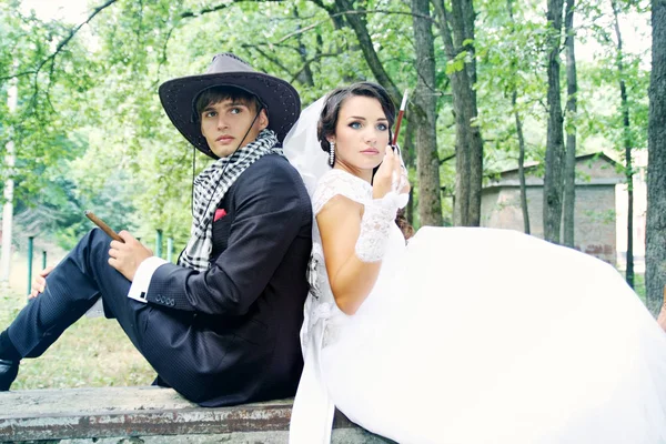美しい花嫁と新郎はカウボーイ ハットで 彼らの煙します — ストック写真