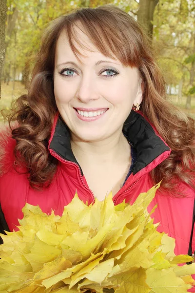 秋の幸せな女性を保持する葉の花束 — ストック写真