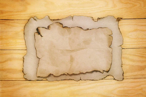 汚れた古い木の板に紙を焼く — ストック写真