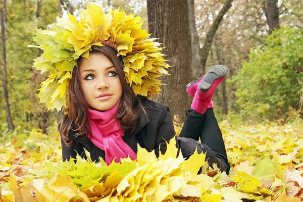 女孩在花圈谎言黄色树叶上 — 图库照片