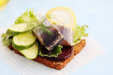 salatalık ve bir dilim ekmek üzerine limon ile ringa balığı