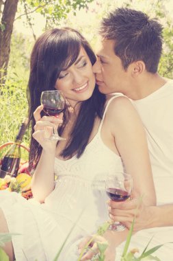 bir kaç kadeh şarap ile bir adam bir kızı öper.