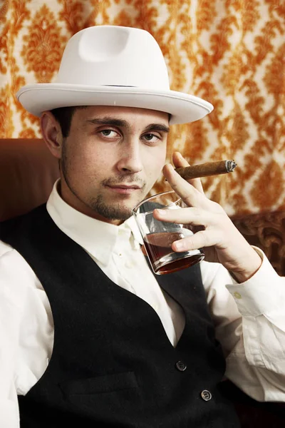 一年轻男子与一支雪茄和一杯威士忌 — 图库照片