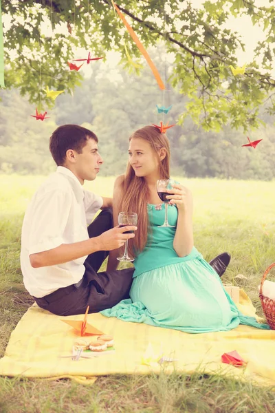 Young couple drinking wine under a tree