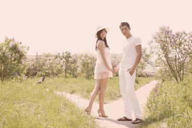  Parkta el ele tutuşan genç çift.