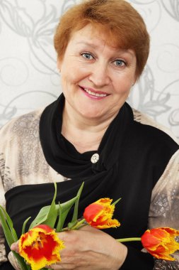 Lale buketi tutan güzel bir yaşlı kadın