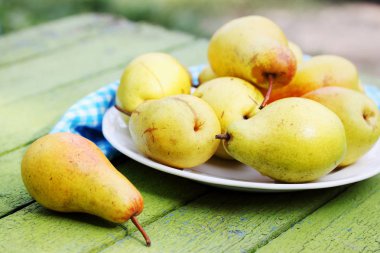 Olgun, sulu, organik armut bir plaka üzerinde