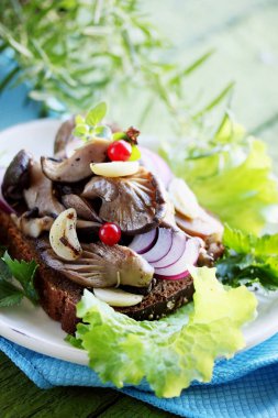  Kızarmış yağlı mantar, sarımsak ve otlar ile sandviç