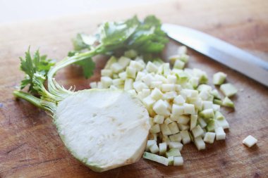 Fresh diced celery on a wooden board clipart