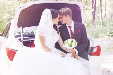 Gelin ve damat arabanın bagajında oturan