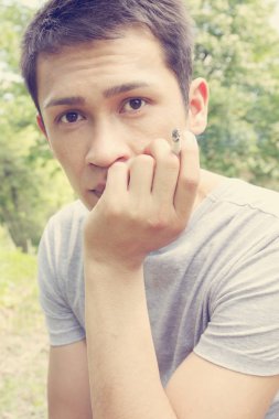 Asyalı genç adam sigara elinde tutan