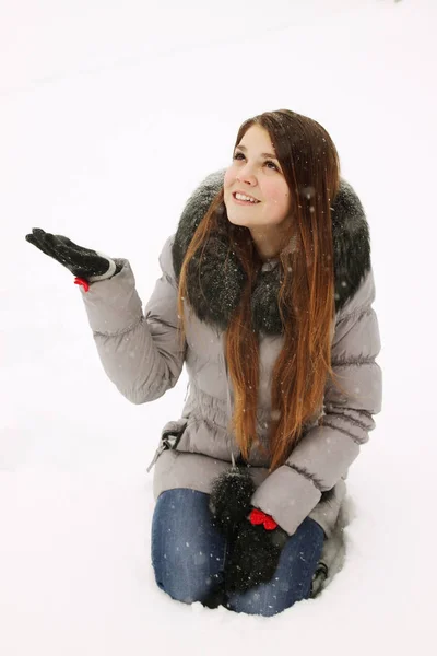 若い女性は雪片を手にキャッチします — ストック写真
