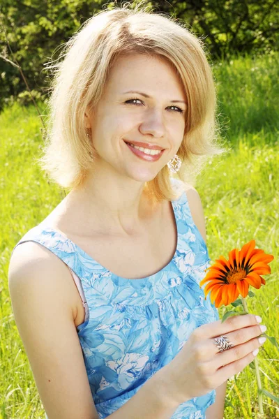 Blondine Hält Orangefarbene Blume Der Hand — Stockfoto