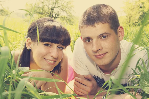 草の上に横たわる美しい若いカップル — ストック写真