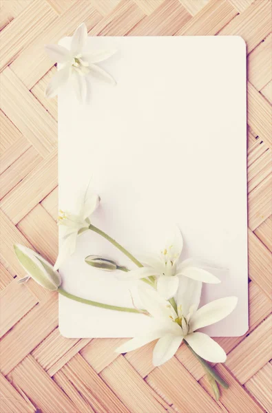 Kleine Weiße Lilien Mit Einer Karte Auf Einem Holzbrett — Stockfoto