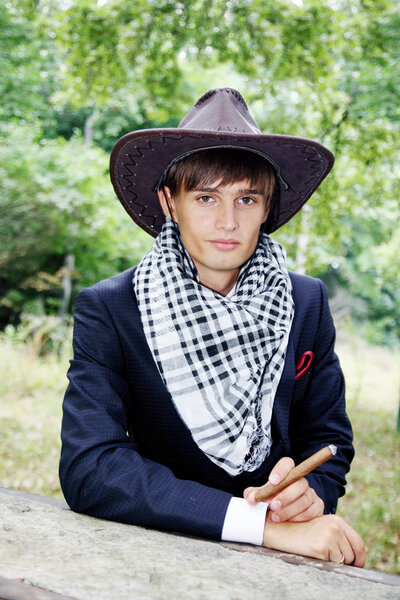 Young handsome guy with a cigar fuming