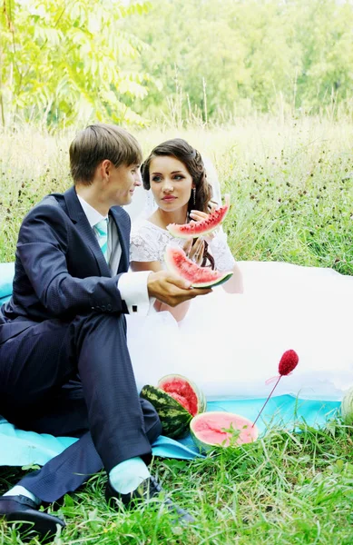 花嫁と新郎がピクニックでスイカを食べる — ストック写真