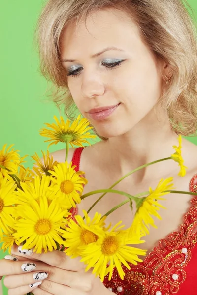 緑の背景に黄色の花とブロンド — ストック写真
