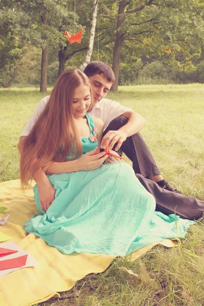 男と女の子を着色 公園でのピクニックで折り紙を行う — ストック写真
