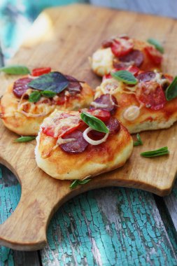 bir ahşap tahta üzerinde küçük ev yapımı pizza